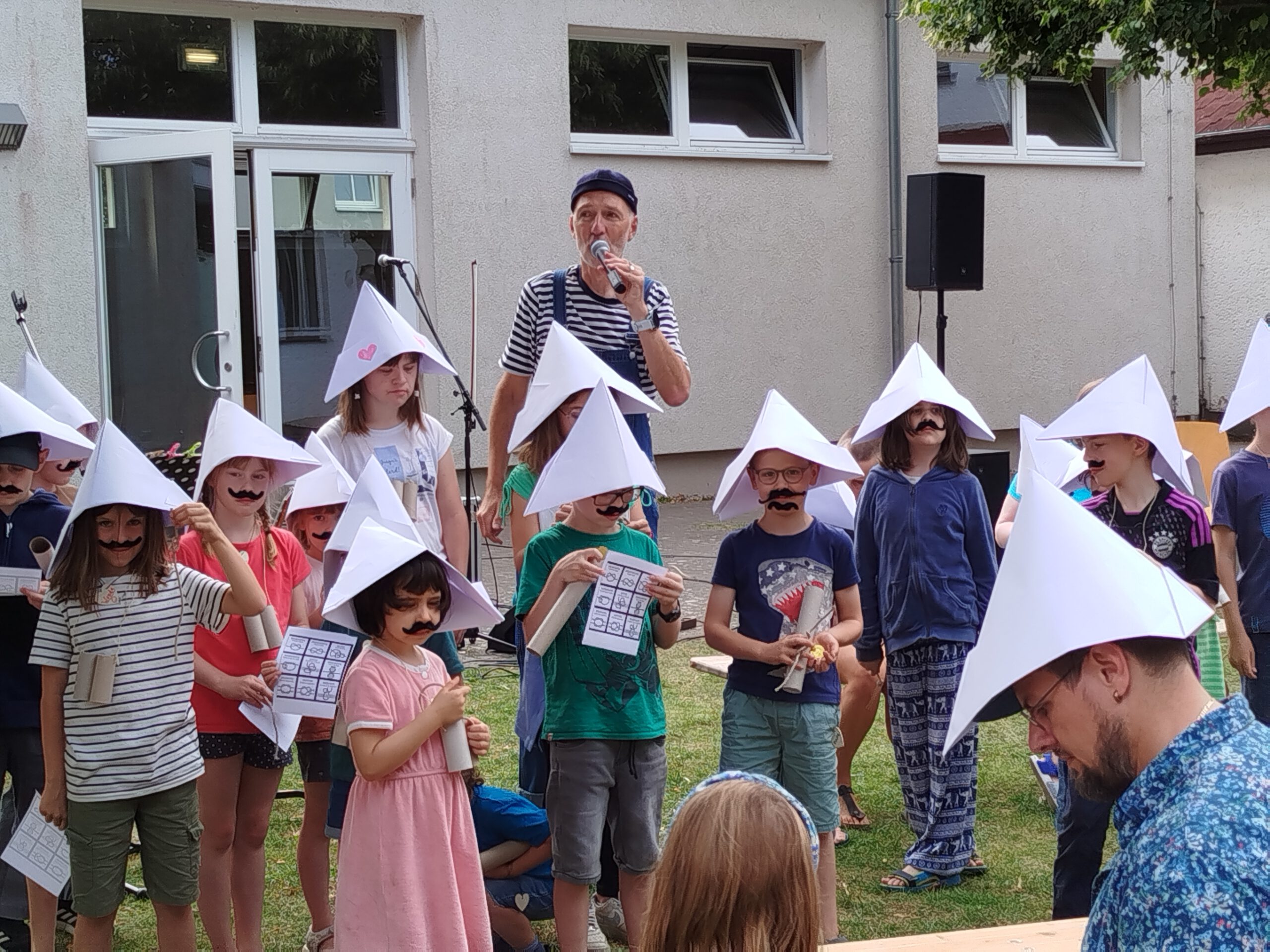 Kinder mit selbstgebastelten Hüten bei einer Freizeit